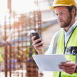 Worker checking mobile phone alert on site
