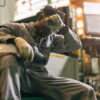 Exhausted industrial worker resting his head, illustrating workplace fatigue