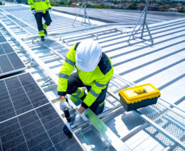 Tradesperson working at height on a rooftop wearing a safety harness