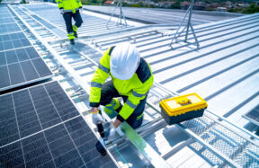 Tradesperson working at height on a rooftop wearing a safety harness