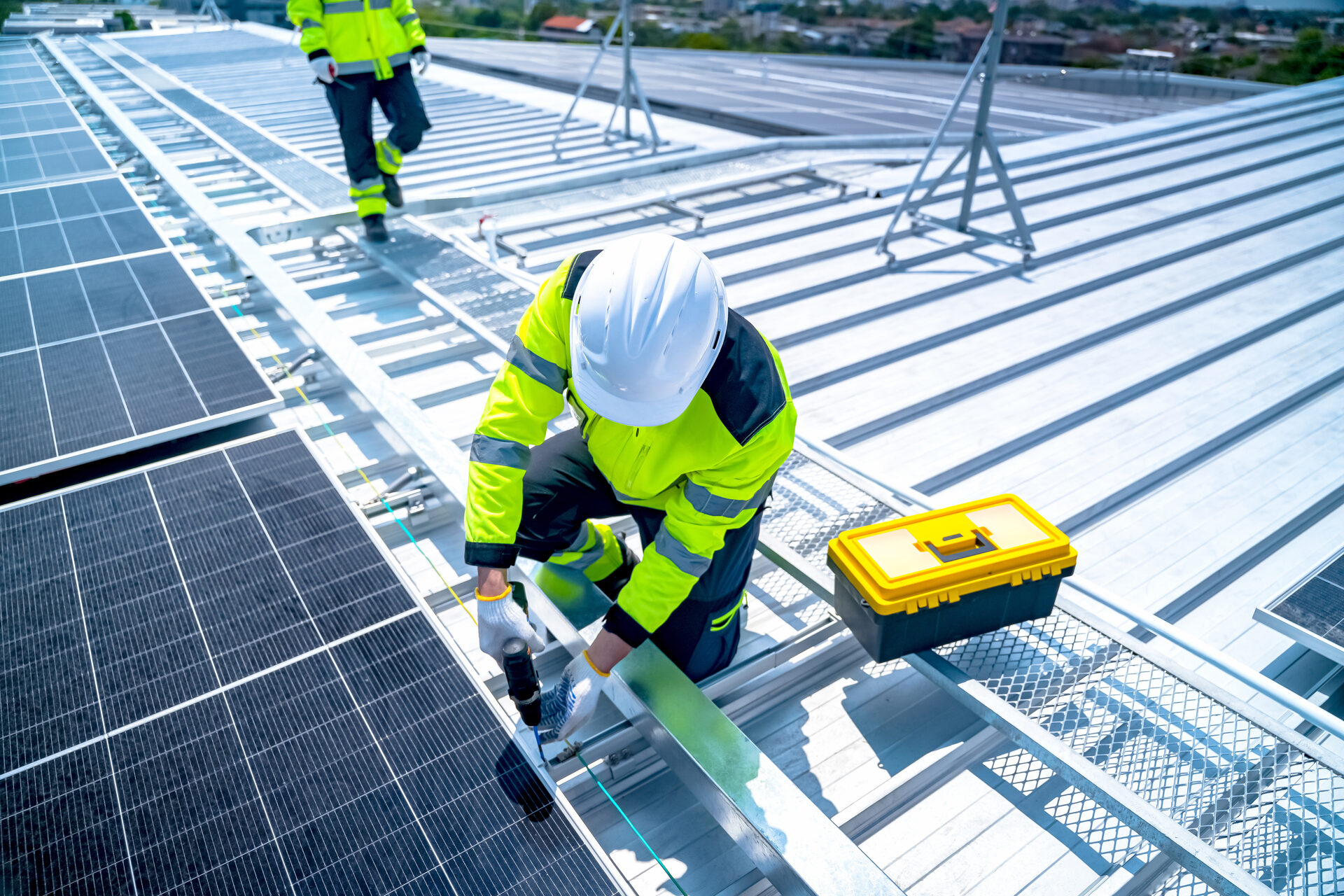 Tradesperson working at height on a rooftop wearing a safety harness
