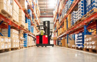 Worker operating a forklift in a distribution warehouse