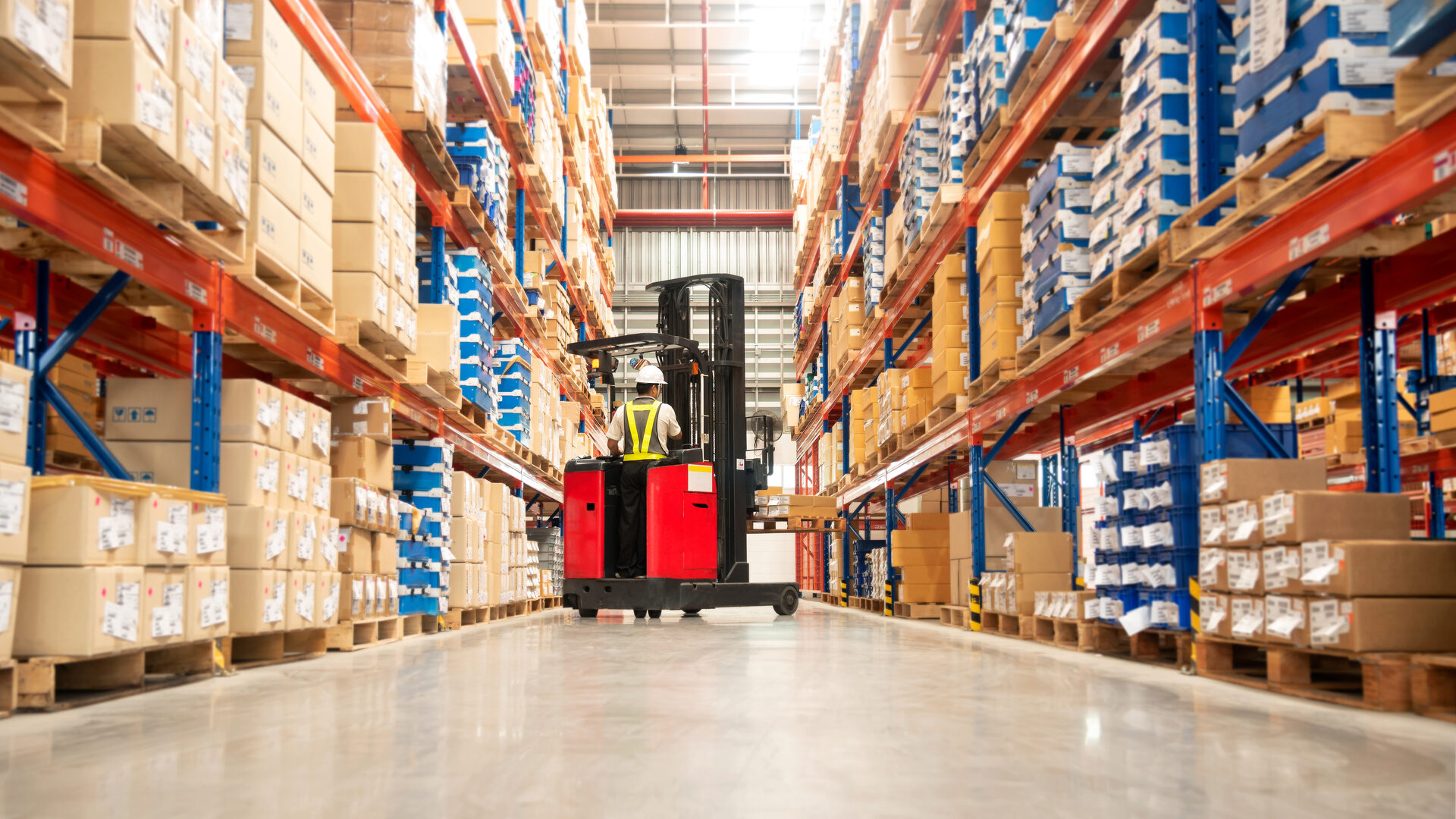Worker operating a forklift in a distribution warehouse