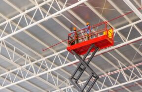 Scissor lift platform elevated toward factory roof