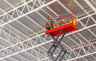 Scissor lift platform elevated toward factory roof