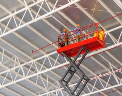 Scissor lift platform elevated toward factory roof