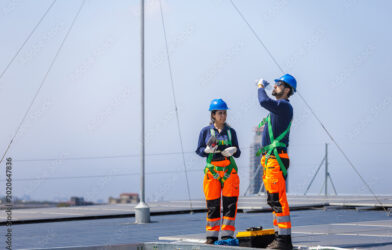 Worker installing solar panels on residential roof without fall protection