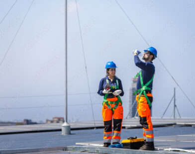 Worker installing solar panels on residential roof without fall protection