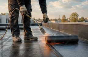 Construction worker applying waterproofing membrane at residential site