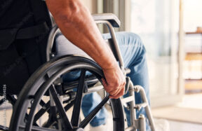 Worker in wheelchair representing workplace injury recovery and safety programs