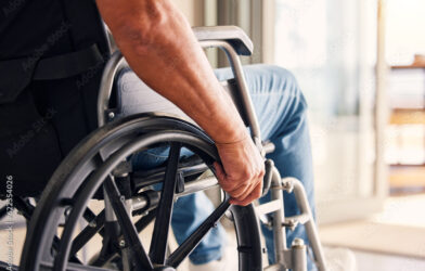 Worker in wheelchair representing workplace injury recovery and safety programs