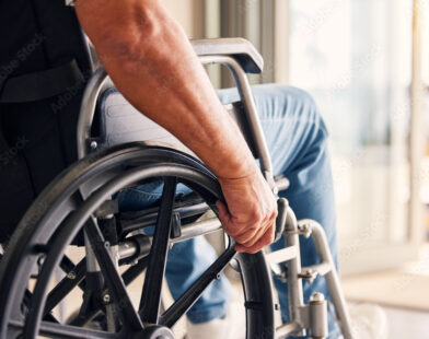 Worker in wheelchair representing workplace injury recovery and safety programs